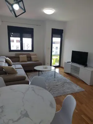 a living room with a couch and a table and a tv at Adriatic Glam in Bar