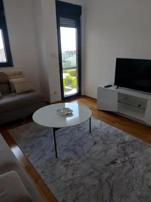 a living room with a coffee table and a television at Adriatic Glam in Bar