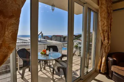 a room with a balcony with a table and chairs at Fidel Apartment in Utjeha