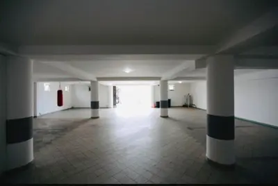an empty parking garage with columns and a hallway at Fidel Apartment in Utjeha