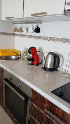 a kitchen counter with a sink and a tea kettle at Fidel Apartment in Utjeha