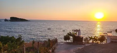 a sunset over the ocean with the sun setting at Fidel Apartment in Utjeha