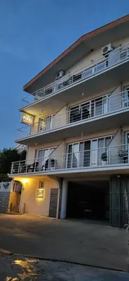 a large apartment building with a parking garage at Fidel Apartment in Utjeha