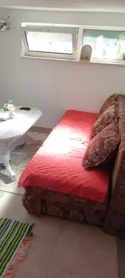 a bed in a room with a table and a window at Apartman Asja in Utjeha