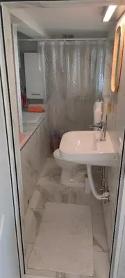 a small bathroom with a sink and a toilet at Apartman Asja in Utjeha
