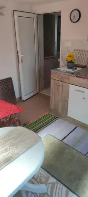 a kitchen with a counter and a sliding door at Apartman Asja in Utjeha