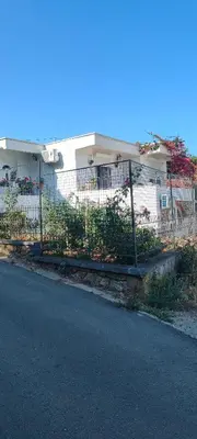 a fence in front of a house with flowers at Apartman Asja in Utjeha