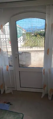 a room with a door with a window and a balcony at Apartman Asja in Utjeha