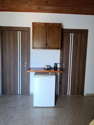 a kitchen with wooden cabinets and a white refrigerator at Villa Serenita in Ulcinj