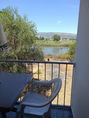 a table and chair on a balcony with a view of a river at Villa Serenita in Ulcinj