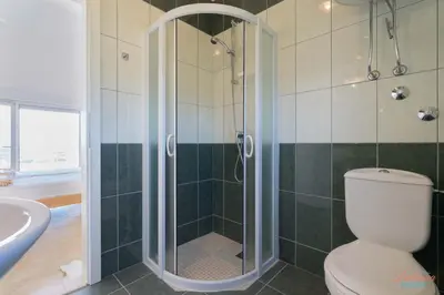 a bathroom with a shower with a toilet and a sink at Dubrava Sea View Apartments in Dobra Voda