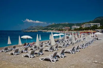 a bunch of lounge chairs and umbrellas on a beach at New Studio - Dobra Voda in Dobra Voda