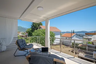 a balcony with two chairs and a laptop on it at Your Adriatic Nest in Bar, Susanj