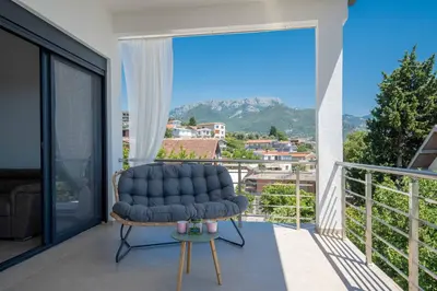 a blue chair on a balcony with a view at Your Adriatic Nest in Bar, Susanj