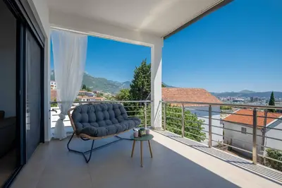 a blue chair sitting on a balcony with a large window at Your Adriatic Nest in Bar, Susanj