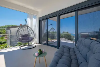 a living room with a blue couch and a swing at Your Adriatic Nest in Bar, Susanj