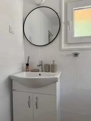 a white bathroom with a sink and a mirror at Apartment Laganini-Bar in Bar, Susanj