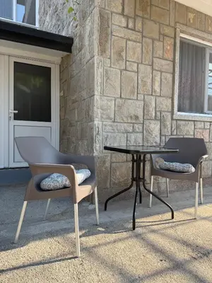 two chairs and a table in front of a building at Apartment Laganini-Bar in Bar, Susanj