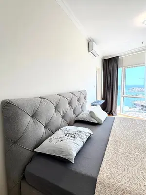 a living room with a gray couch with two pillows at Luxury penthouse in Tre Canne complex in Budva