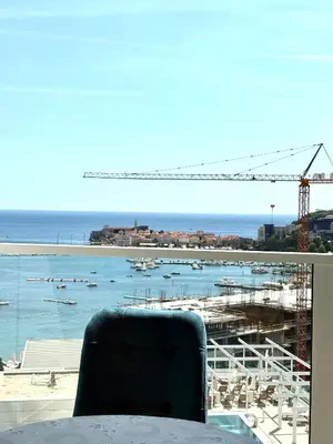 a chair sitting at a table with a view of a beach at Luxury penthouse in Tre Canne complex in Budva