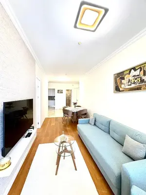 a living room with a blue couch and a table at Luxury penthouse in Tre Canne complex in Budva