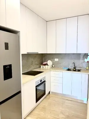a white kitchen with white cabinets and a sink at Luxury penthouse in Tre Canne complex in Budva
