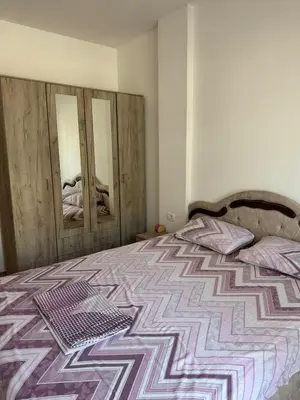 a bedroom with a bed and two wooden doors at Apartment Gardo in Budva