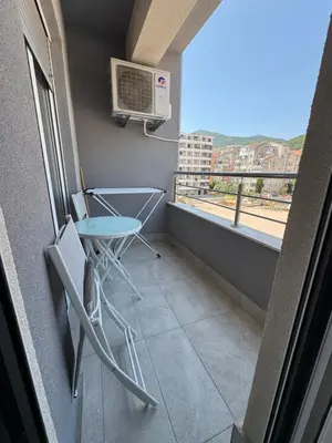 a balcony with a table and a microwave on the wall at Apartment Gardo in Budva