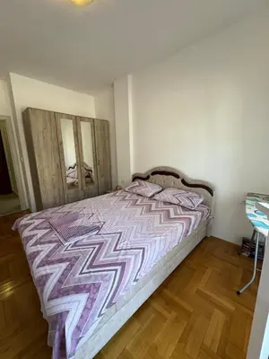 a bedroom with a bed with a purple comforter at Apartment Gardo in Budva