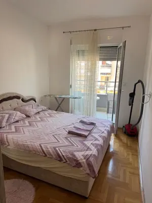 a bedroom with a bed and a glass door to a balcony at Apartment Gardo in Budva