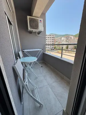 a balcony with a table and a heater on the wall at Apartment Gardo in Budva