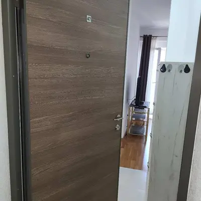a wooden door in a room with a television at Stan Na Dan Podgorica Zabjelo1 in Podgorica