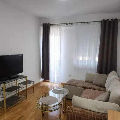 a living room with a couch and a flat screen tv at Stan Na Dan Podgorica Zabjelo1 in Podgorica
