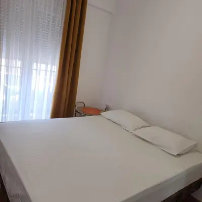 a white bed in a room with a window at Stan Na Dan Podgorica Zabjelo1 in Podgorica