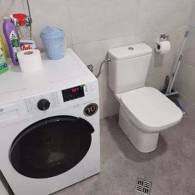 a bathroom with a toilet and a washing machine at Stan Na Dan Podgorica Zabjelo1 in Podgorica