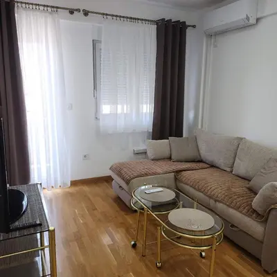 a living room with a couch and two tables at Stan Na Dan Podgorica Zabjelo1 in Podgorica