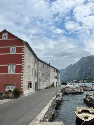 a building next to a river with a boat in the water at Villa Kotor Air in Muo