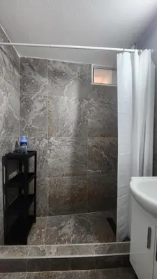 a bathroom with a shower curtain and a sink at Villa Kotor Air in Muo