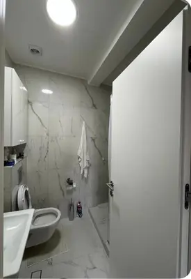 a white bathroom with a toilet and a sink at Soho City A in Bar