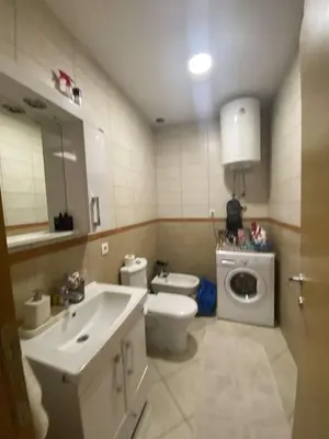 a bathroom with a toilet sink and a washing machine at Pico apartments in Ulcinj