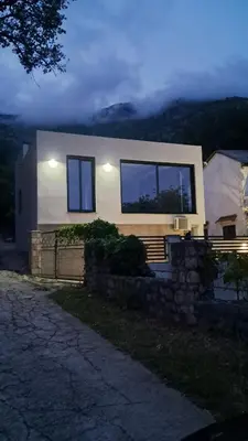 a house with windows and a stone wall at B&L Apartmani in Sutomore