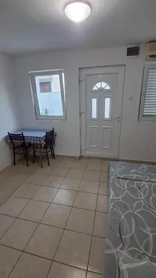 a room with a table and a window and a door at B&L Apartmani in Sutomore