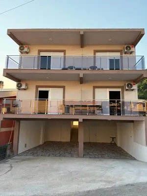 a building with a balcony with tables and chairs at NOVO 2025 Apartmani 4S in Kravlja