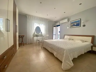 a bedroom with a bed and a table and a window at Villa Maja in Sutomore