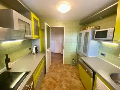 a kitchen with yellow and green cabinets and a sink at Villa Maja in Sutomore