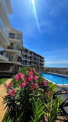 a large apartment building with a pool and pink flowers at Casa Montenegro Lux Apartment 1 Bedroom 1 livingroom Sea & Pool View in Tivat