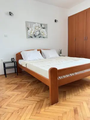 a bed in a bedroom with a wooden floor at Cozy one-bedroom apartment in the city center in Bar