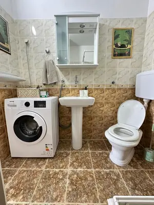 a bathroom with a washing machine and a sink at Cozy one-bedroom apartment in the city center in Bar