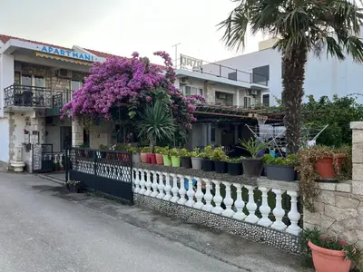 a fence with potted plants on it next to a building at Apartmani OAZA 2 in Ulcinj