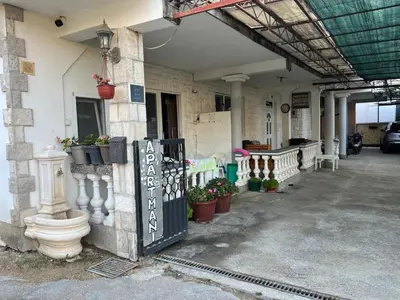 a building with a gate and potted plants on it at Apartmani OAZA 2 in Ulcinj